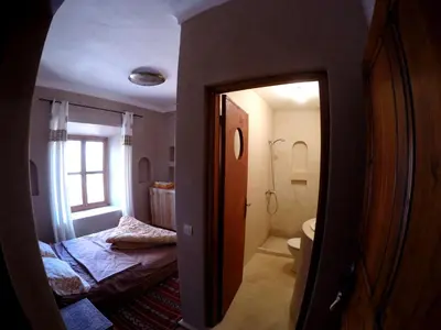 a room with a bathroom with a bed and a toilet at La Kasbah du M'goun in Timit