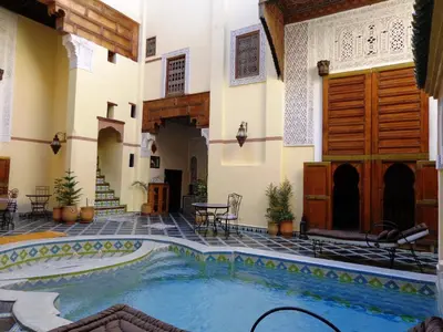 an indoor swimming pool in a building with a courtyard at Riad Zitouna in Fès