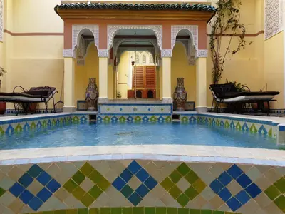 a swimming pool in a building with a tile floor at Riad Zitouna in Fès