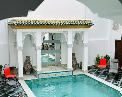 a swimming pool in a house with a tub in the middle at Riad Zitouna in Fès