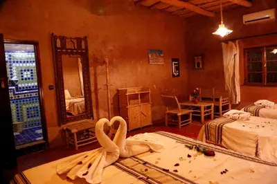 a room with two beds and a swan on the floor at Riad Maktoub in Aït Ben Haddou