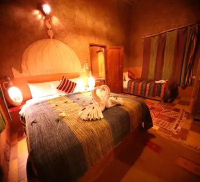 a bedroom with a bed with two swans on it at Riad Maktoub in Aït Ben Haddou