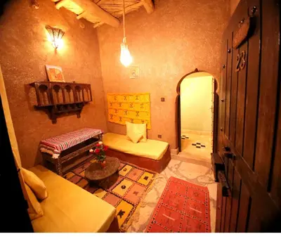 a living room with a bed and a couch at Riad Maktoub in Aït Ben Haddou