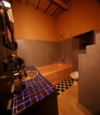 a bathroom with a tub and a sink and a toilet at Riad Maktoub in Aït Ben Haddou