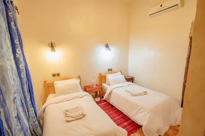 a room with two beds in a room at Riad Mamouche in Merzouga