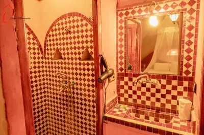 a bathroom with a sink and a mirror at Riad Mamouche in Merzouga