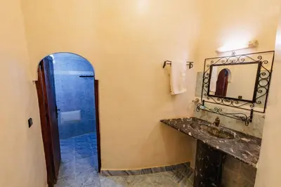 a bathroom with a sink and a mirror at Riad Mamouche in Merzouga