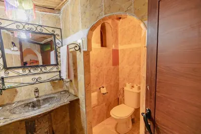 a bathroom with a toilet and a sink and a mirror at Riad Mamouche in Merzouga