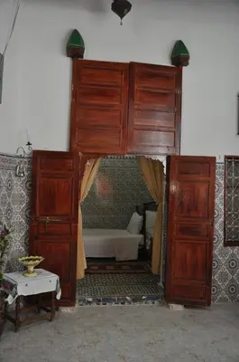 a large wooden canopy bed in a bedroom at La Colombe Blanche in Moulay Idriss Zerhoun