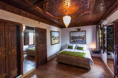 a bedroom with a bed and a chandelier at Riad Fes Andalucia in Fès
