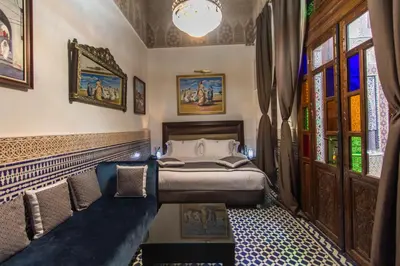 a bedroom with a bed and a couch at Riad Fes Andalucia in Fès