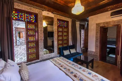 a bedroom with a bed and stained glass windows at Riad Fes Andalucia in Fès