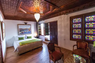 a bedroom with a bed and a stained glass window at Riad Fes Andalucia in Fès