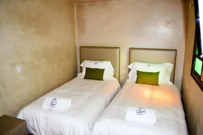 two beds sitting next to each other in a room at Riad Fes Andalucia in Fès