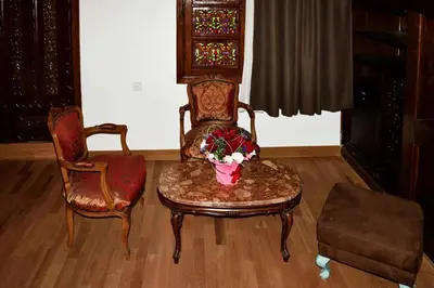 a living room with two chairs and a vase of flowers at Riad Fes Andalucia in Fès