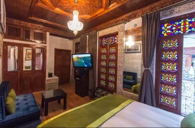 a bedroom with a bed and stained glass windows at Riad Fes Andalucia in Fès