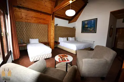a hotel room with two beds and a couch at L'empreinte D'ifrane in Ifrane