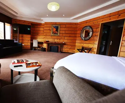 a bedroom with a bed and a couch and a fireplace at L'empreinte D'ifrane in Ifrane