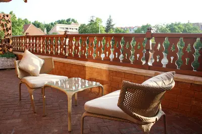 a patio with two chairs and a table and a fence at L'empreinte D'ifrane in Ifrane