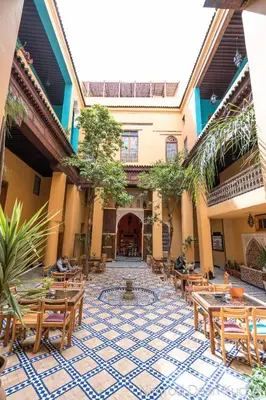 a courtyard with tables and chairs in a building at Medina social club in Fès
