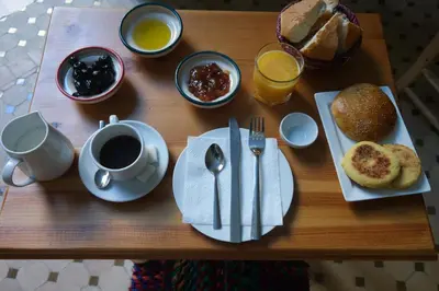 a table topped with plates of food and a cup of coffee at Medina social club in Fès