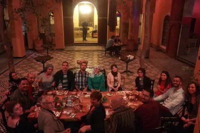 a group of people sitting around a dinner table at Medina social club in Fès