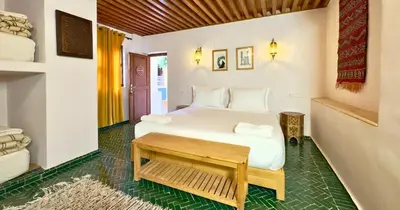 a bedroom with a white bed and a table at Medina social club in Fès