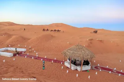a group of people riding horses in the desert at Sahara Desert Luxury Camp in Merzouga