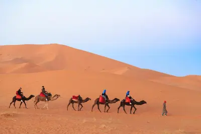 a group of people riding horses in the desert at Sahara Desert Luxury Camp in Merzouga