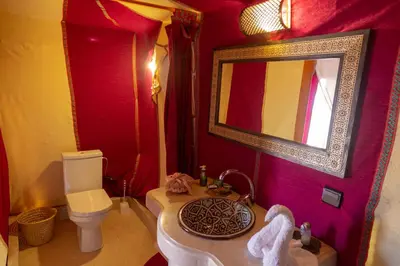 a bathroom with a sink and a toilet and a mirror at Sahara Desert Luxury Camp in Merzouga