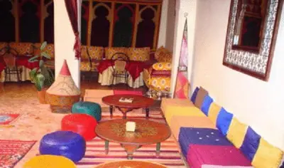 a living room with a couch and tables and chairs at Ryad Bahia in Meknès