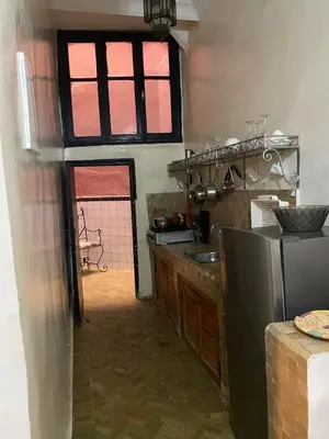 a kitchen with a sink and a window and a refrigerator at dar hassbia in Fès