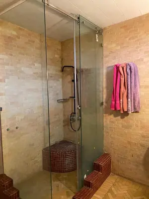 a glass shower with pink towels hanging on a wall at dar hassbia in Fès