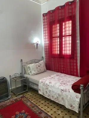 a bedroom with a bed and a red window at dar hassbia in Fès
