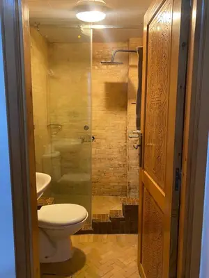a bathroom with a toilet and a glass shower at dar hassbia in Fès