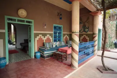 a living room with a couch in a house at Fibule Du Draa Kasbah D'hôtes in Zagora