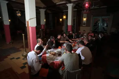 a group of people sitting at tables in a room at Fibule Du Draa Kasbah D'hôtes in Zagora