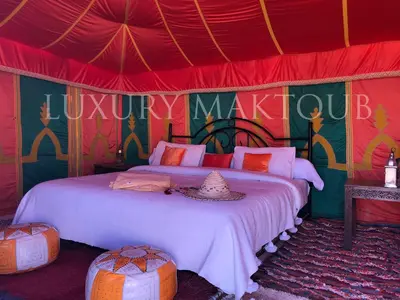 a bedroom with a bed in a circus tent at Luxury Maktoub in Merzouga