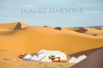 a desert view of a white building in the desert at Luxury Maktoub in Merzouga