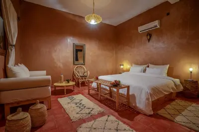 a bedroom with a bed and a couch and a chair at Hotel Kasbah Sahara Services - M'Hamid El Ghizlane in Mhamid