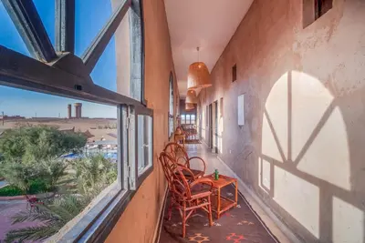a balcony with chairs and a table and a window at Hotel Kasbah Sahara Services - M'Hamid El Ghizlane in Mhamid