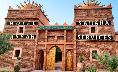 a brick building with a hotel and saharan services at Hotel Kasbah Sahara Services - M'Hamid El Ghizlane in Mhamid