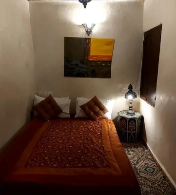 a bedroom with a bed in a room with a lamp at Palais AL Firdaous in Fès