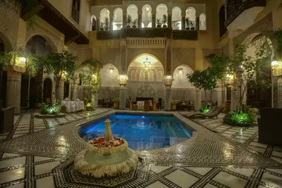 a pool in a building with a fountain in the middle at Riad Salam Fes & Spa in Fès