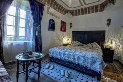 a bedroom with a bed and a table in it at Riad Salam Fes & Spa in Fès