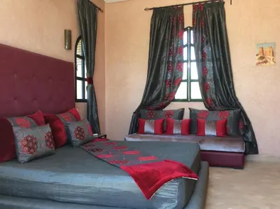 a bedroom with a bed and a couch and a window at Villa TYCOZ in Marrakech