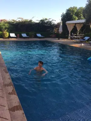 a man swimming in a swimming pool at Villa TYCOZ in Marrakech
