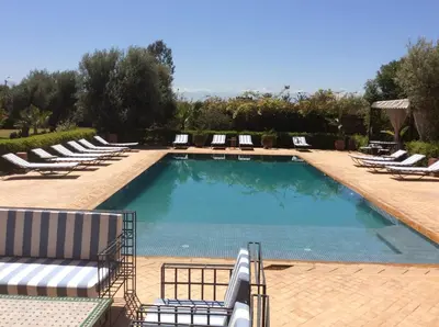 a large swimming pool with lounge chairs and a bunch at Villa TYCOZ in Marrakech