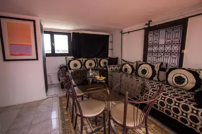 a living room with a table and chairs and a couch at Hôtel Fontaine Campini in Fès