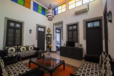 a living room with a couch and a table at Hôtel Fontaine Campini in Fès
